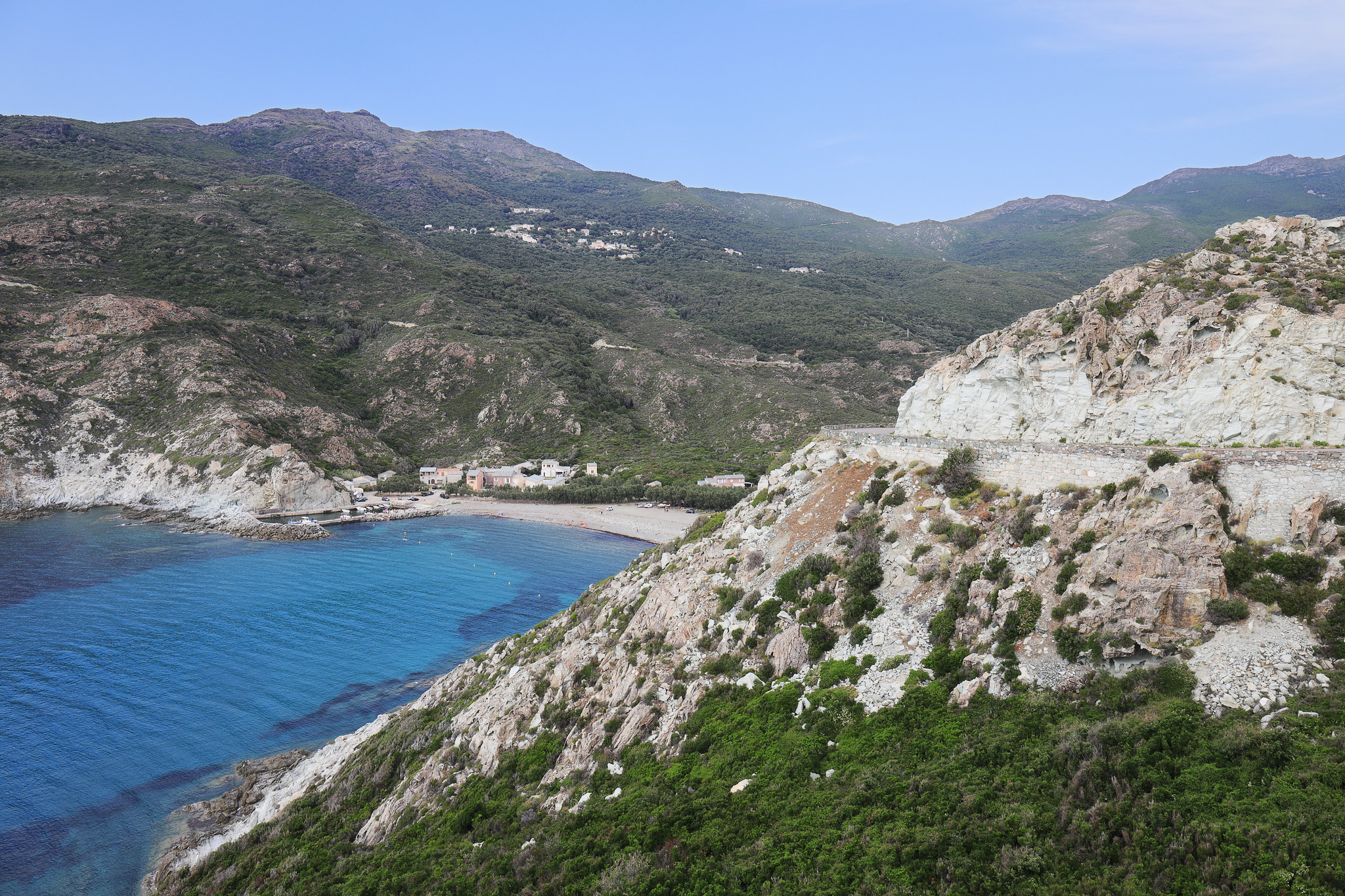 Paysage du Cap Corse avec route, montagnes, habitations et une plage