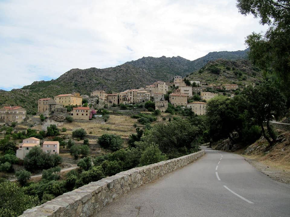 Paysage du village de Lama en Corse. Route, arbres, maisons et végétation.